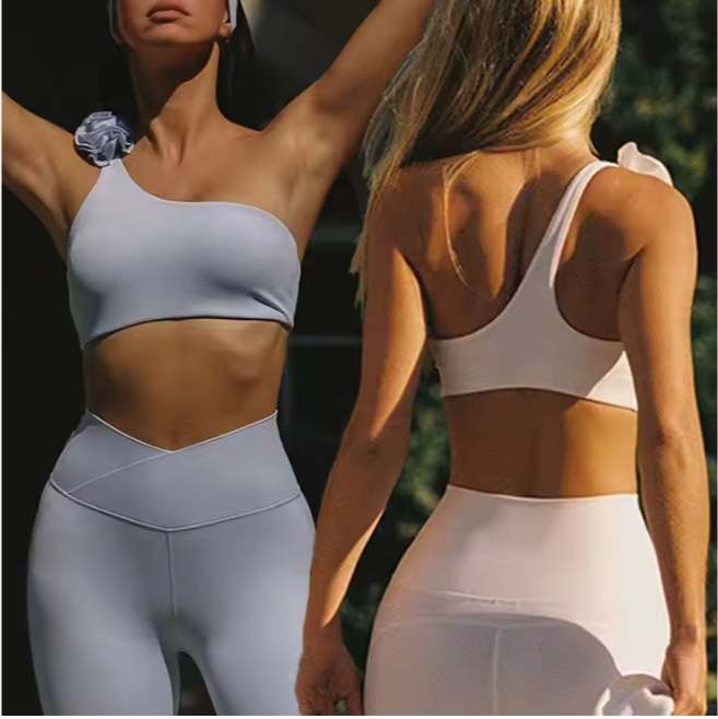 Elevate your workout style with the Women’s One-Shoulder Floral Sports Bra Top with Skirt or Legging Set — a chic fusion of fashion and performance. The asymmetrical one-shoulder design adds a bold, modern touch, while the floral detailing gives it a soft and feminine elegance. This 2-piece set includes a floral sports bra top offering light to medium support and your choice of a bubble skirt for a trendy sporty look or high-waist leggings for full flexibility and coverage. Made from breathable, stretchable, and moisture-wicking fabric, this outfit is perfect for yoga, fitness, dance, or casual athleisure wear. Features: One-shoulder floral sports bra for a stylish asymmetrical look Option of bubble skirt or high-waist leggings Soft, stretchable, and quick-dry fabric for comfort and mobility Feminine and sporty design suitable for any occasion Perfect for yoga, pilates, gym, or streetwear 2-piece coordinated activewear set